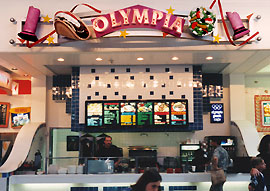 Greek restaurant storefront with signage and sculptures